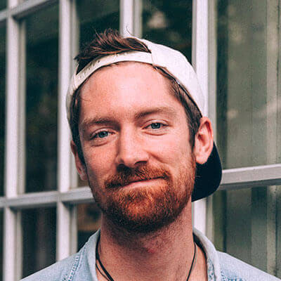 A drawing of two monitors facing each other, with light toned hands reaching out from each monitor, one holding a credit card, the other a small shopping bag.